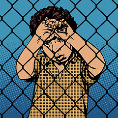 Image showing Child boy refugee migrants behind bars the prison boundary