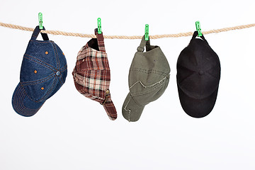 Image showing Four Caps On A Clothesline