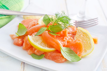 Image showing fresh salmon with lemon on the white plate