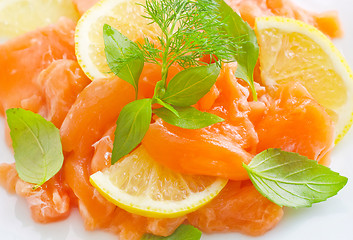 Image showing fresh salmon with lemon on the white plate