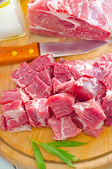 Image showing raw meat and knife on the wooden board