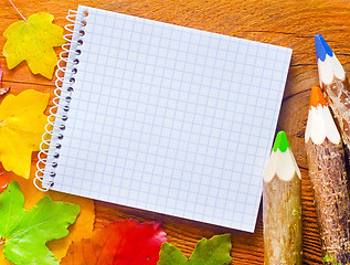 Image showing leaves and note on wooden background