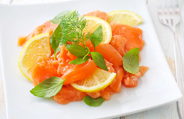 Image showing fresh salmon with lemon on the white plate