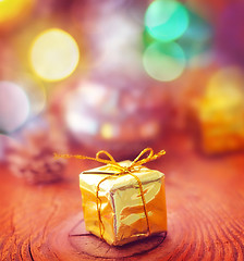 Image showing Gold present and cristmas decoration on the wooden board