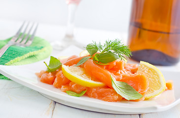 Image showing fresh salmon with lemon on the white plate