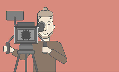 Image showing Cameraman with beard looking through movie camera