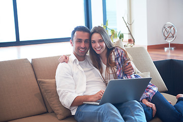 Image showing relaxed young couple working on laptop computer at home