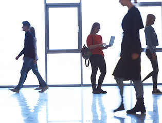 Image showing student girl standing with laptop, people group passing by