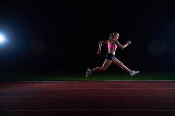 Image showing Athletic woman running on track