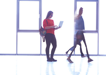 Image showing student girl standing with laptop, people group passing by