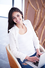 Image showing relaxed young woman at home working on laptop computer