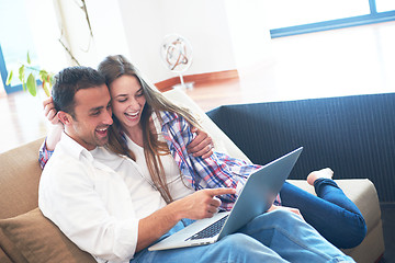 Image showing relaxed young couple working on laptop computer at home