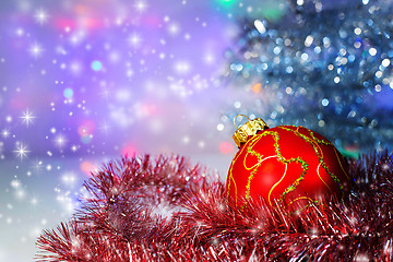 Image showing Red Christmas ball under the tree and tinsel.Christmas decoratio
