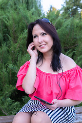 Image showing Smiling brunette listening to music with tablet