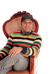 Image showing Happy middle age man sitting in armchair.