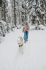 Image showing The woman with a dog on walk in a winter wood