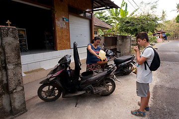 Image showing Woman sell benzine in plastic bottle