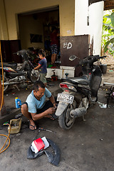 Image showing Service man repair deflated damaged tyre