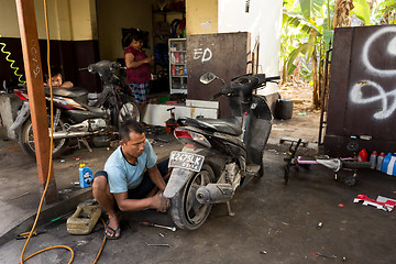 Image showing Service man repair deflated damaged tyre