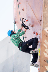 Image showing Man climbs upward on ice climbing competition