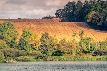 Image showing Agricultural hillside fields above a lake