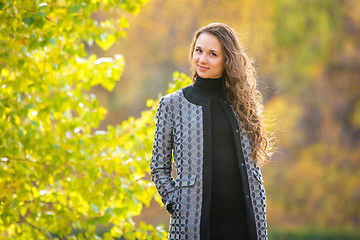 Image showing Cute young girl on the background of the autumn yellow foliage