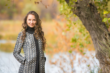 Image showing Portrait of a young girl near the tree on a background of autumn river