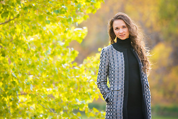 Image showing Cute young girl on the background of the autumn yellow forests