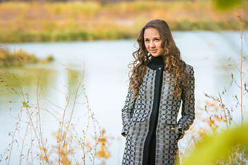 Image showing Portrait of a young girl on a background of the autumn river