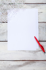 Image showing The blank sheet of paper on the wooden table with a pen 