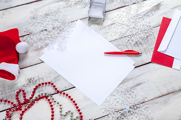 Image showing The blank sheet of paper on the wooden table with a pen 