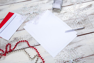 Image showing The blank sheet of paper on the wooden table with a pen 