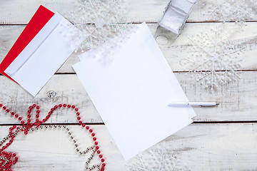 Image showing The blank sheet of paper on the wooden table with a pen 