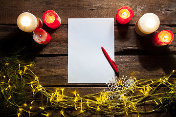 Image showing The blank sheet of paper on the wooden table with a pen 