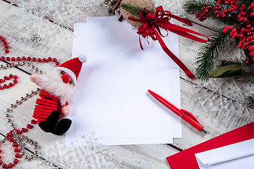 Image showing The blank sheet of paper on the wooden table with a pen 