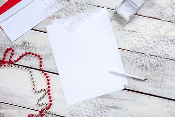 Image showing The blank sheet of paper on the wooden table with a pen 