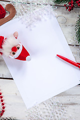 Image showing The blank sheet of paper on the wooden table with a pen 