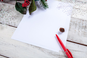 Image showing The blank sheet of paper on the wooden table with a pen 