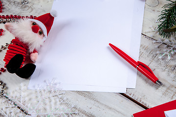 Image showing The blank sheet of paper on the wooden table with a pen 