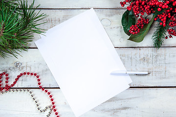 Image showing The blank sheet of paper on the wooden table with a pen 