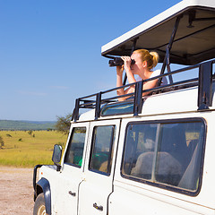 Image showing Woman on safari looking through binoculars.