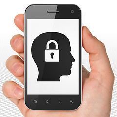 Image showing Information concept: Hand Holding Smartphone with Head With Padlock on display