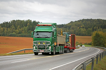 Image showing Green Volvo FH Hauls Yanmar Mini Excavator 