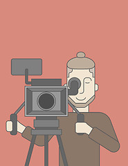 Image showing Cameraman with beard looking through movie camera