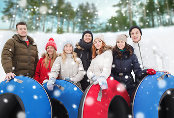 Image showing group of smiling friends with snow tubes