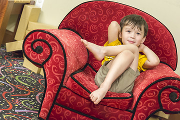 Image showing Mixed Race Boy Relaxing in Comfortable Red Arm-Chair