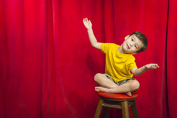 Image showing Mixed Race Boy Sitting on Stool in Front of Curtain