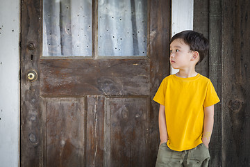 Image showing Melancholy Mixed Race Boy Standing In Front of Door