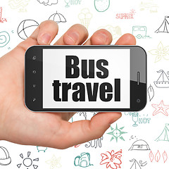 Image showing Tourism concept: Hand Holding Smartphone with Bus Travel on display