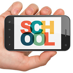 Image showing Education concept: Hand Holding Smartphone with School on  display